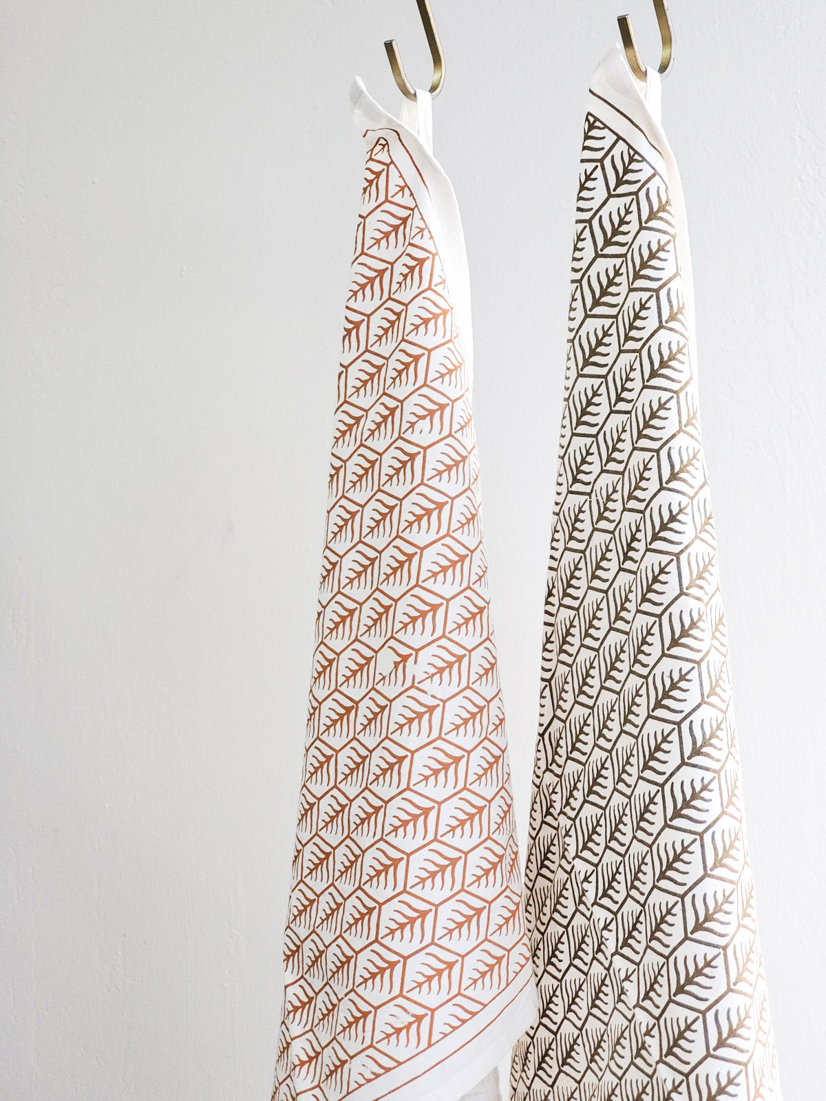 Hanging printed tea towels with closeup of Korissa label