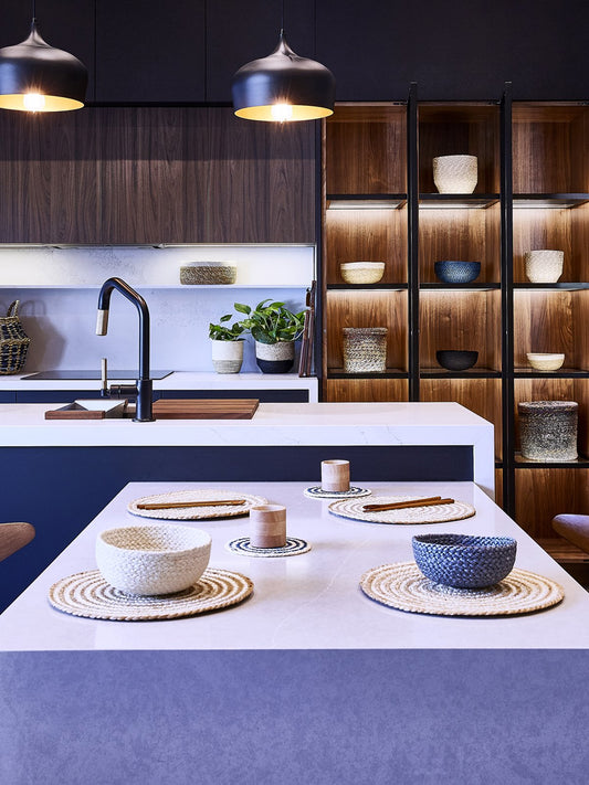 spiral jute coaster set in blue styled on a table top with other items